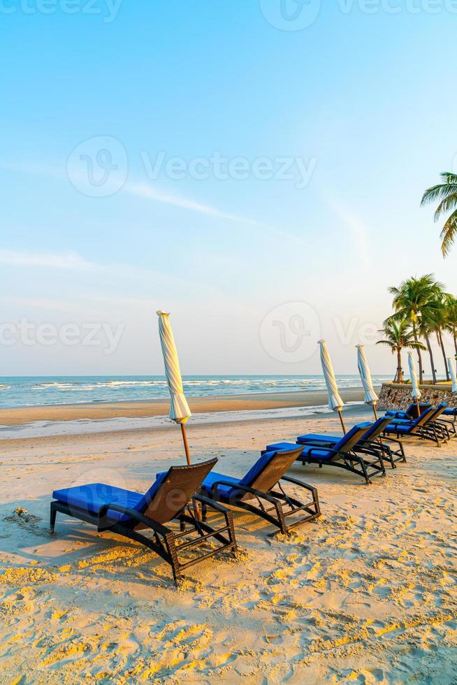 Empty beach chair on beach with sea and sky background photo