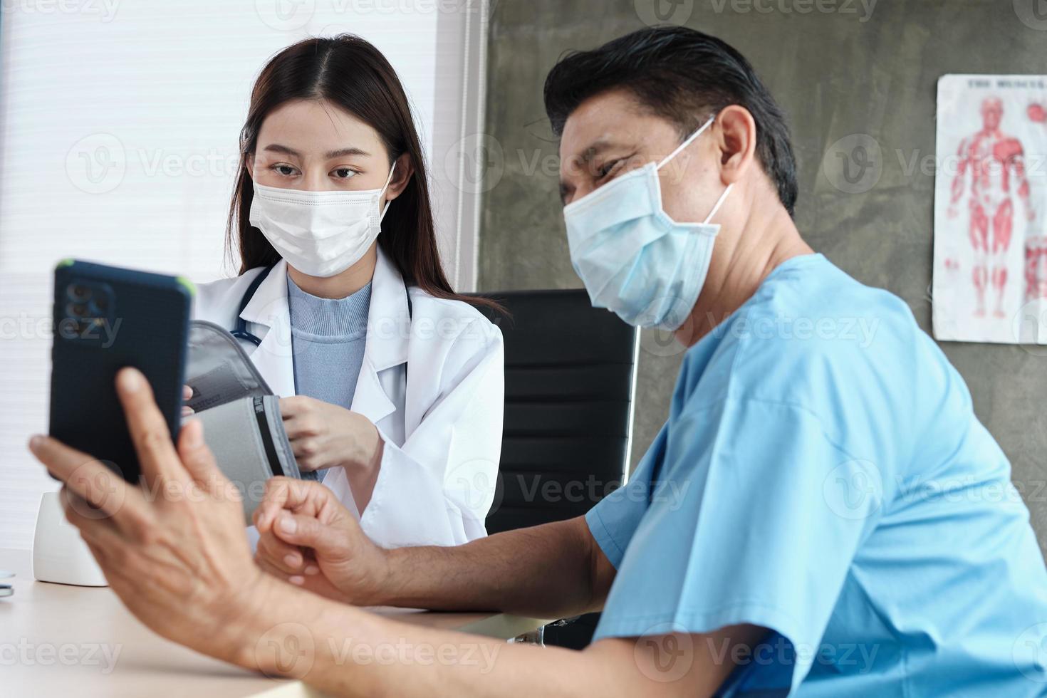 Paciente masculino con mascarilla al que se le pidió que se tomara un selfie con una doctora. foto