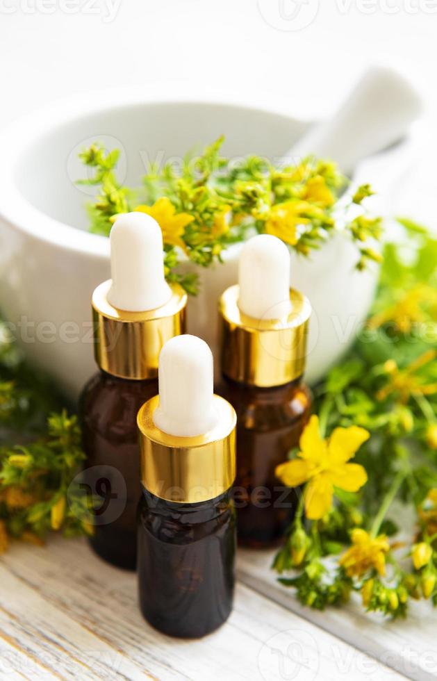 St johns wort oils, and  fresh herbs in a mortar photo