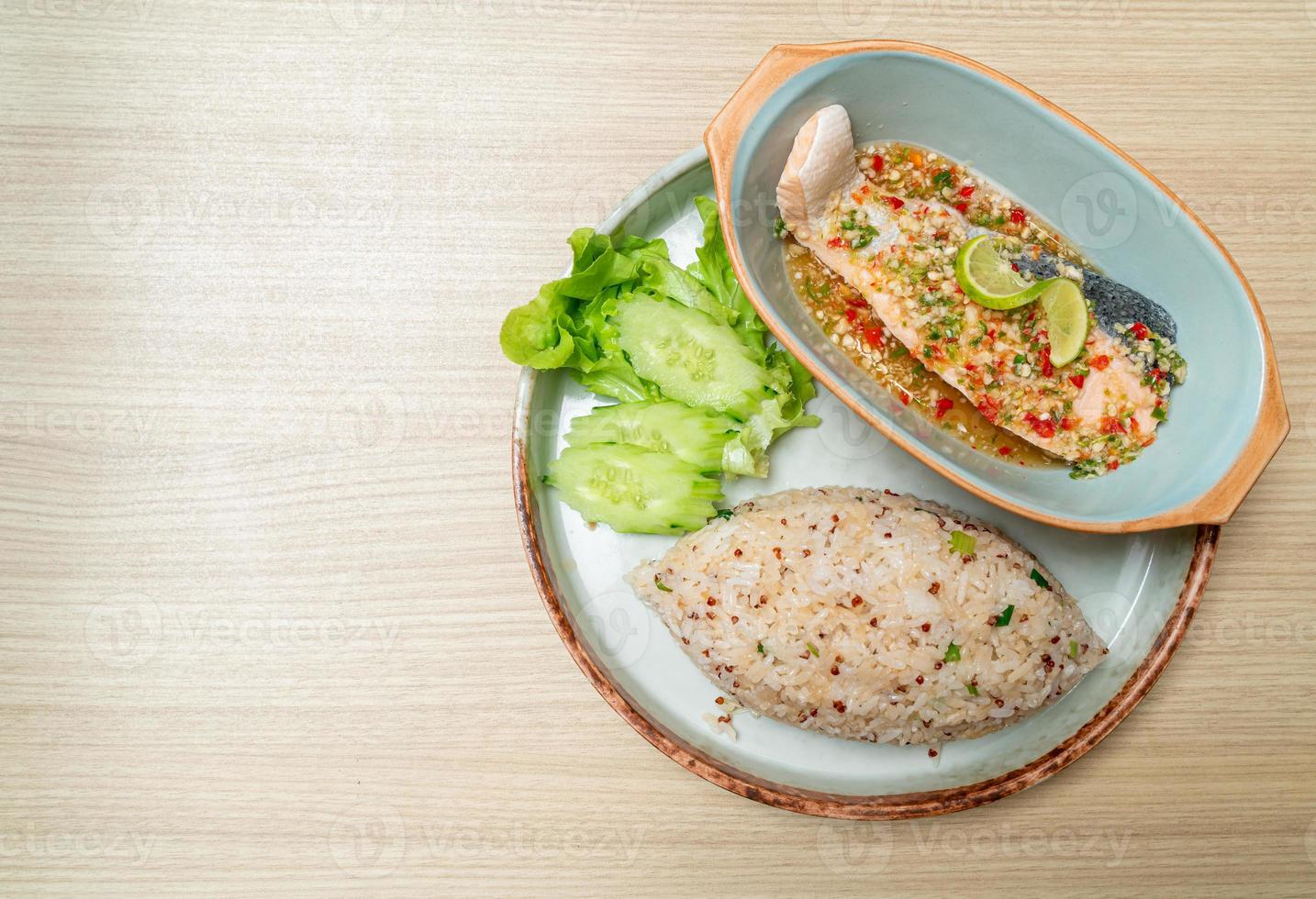 Quinoa fried rice with steamed salmon in lime chili dressing - healthy food style photo