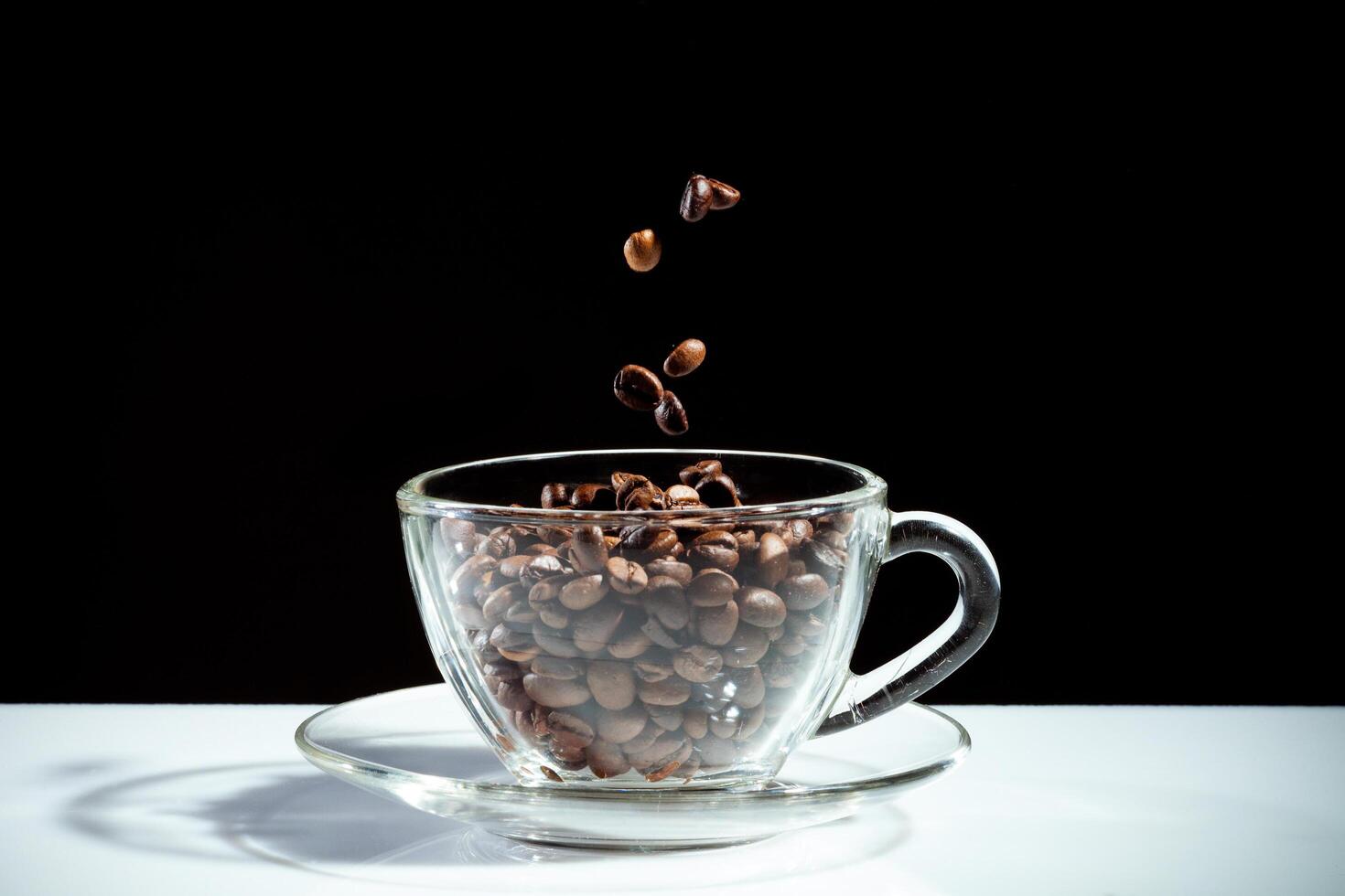 taza de café con frijoles cayendo foto