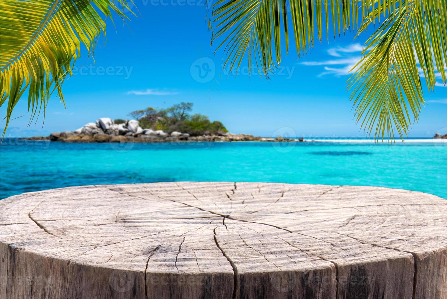 Stump table on sandy beach with blurred blue sea background. photo