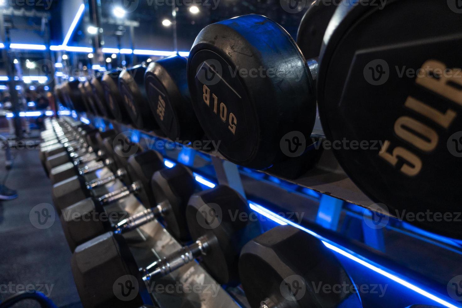 mancuernas colocadas en estantes en el gimnasio para hacer ejercicio. foto