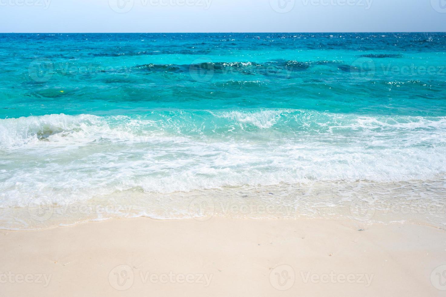 Clear sea waves and white sandy beach in summer. photo