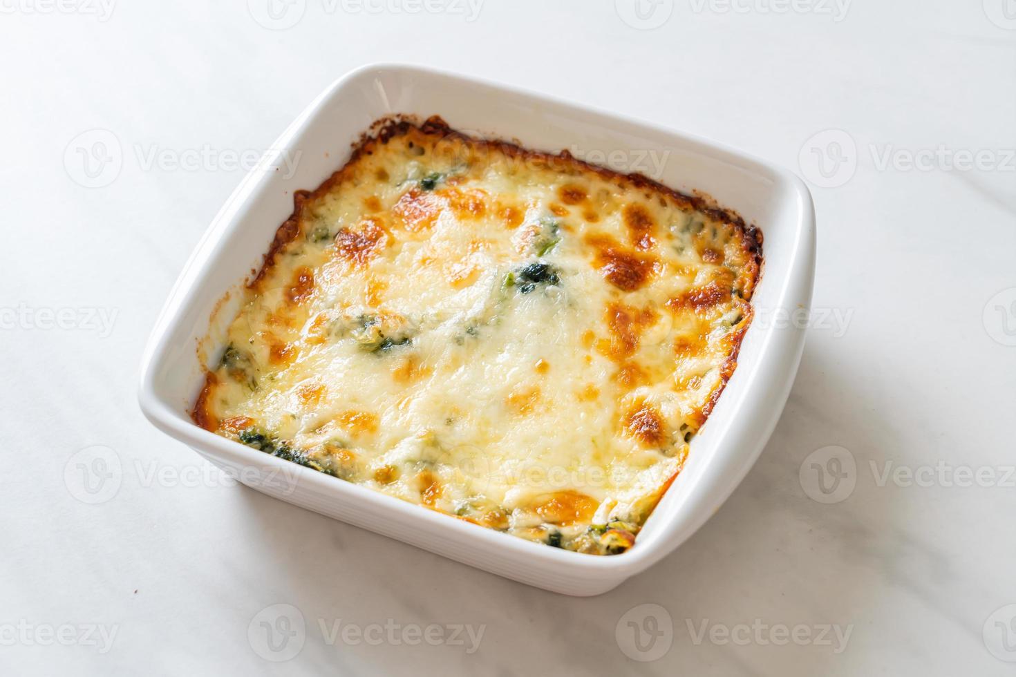 Baked spinach lasagna with cheese in white plate photo