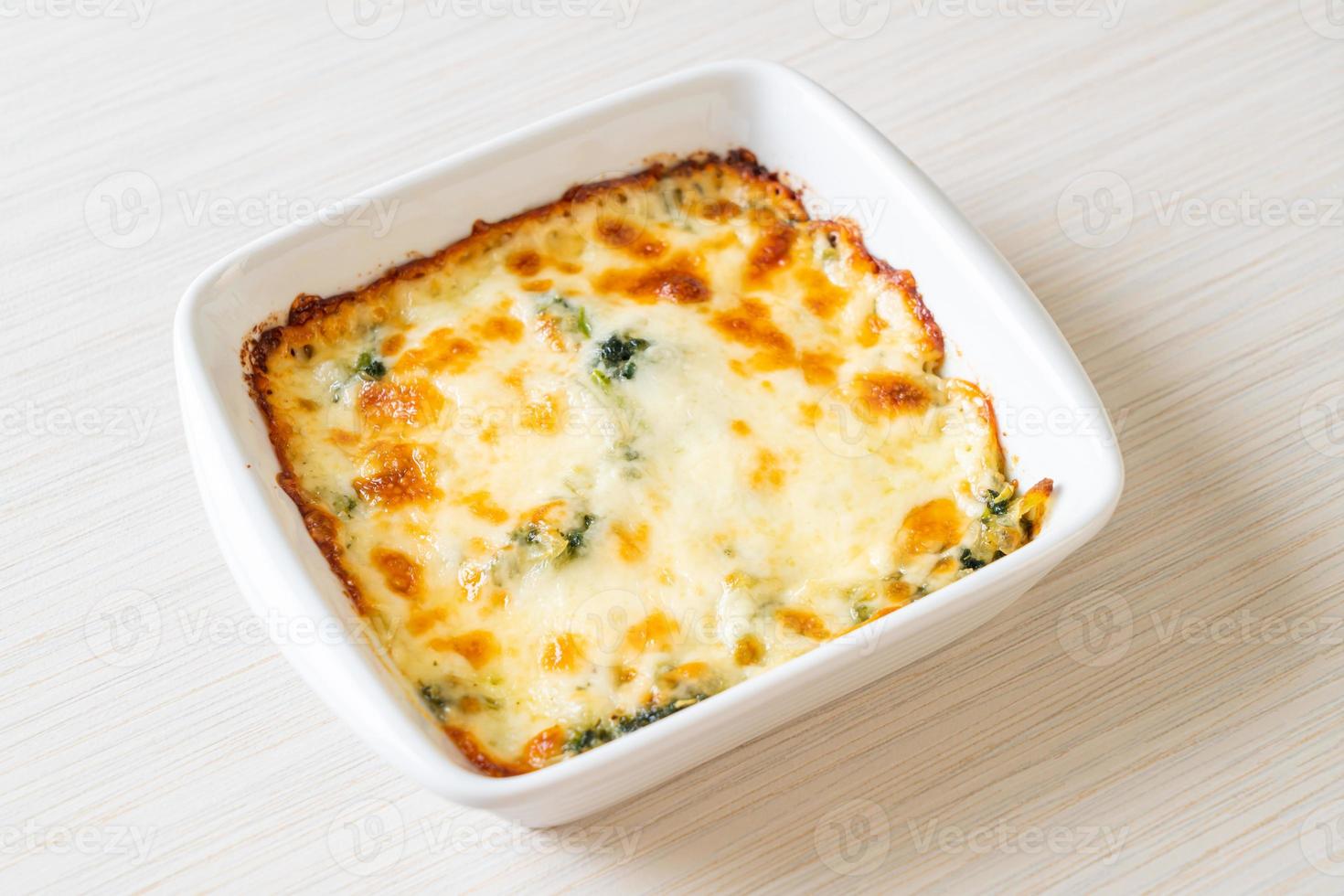 Lasaña de espinacas al horno con queso en placa blanca. foto