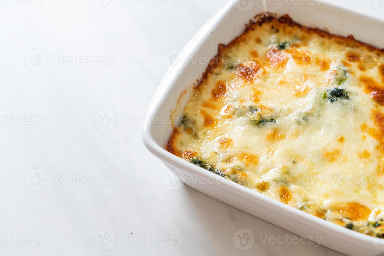 Lasaña de espinacas al horno con queso en placa blanca. foto