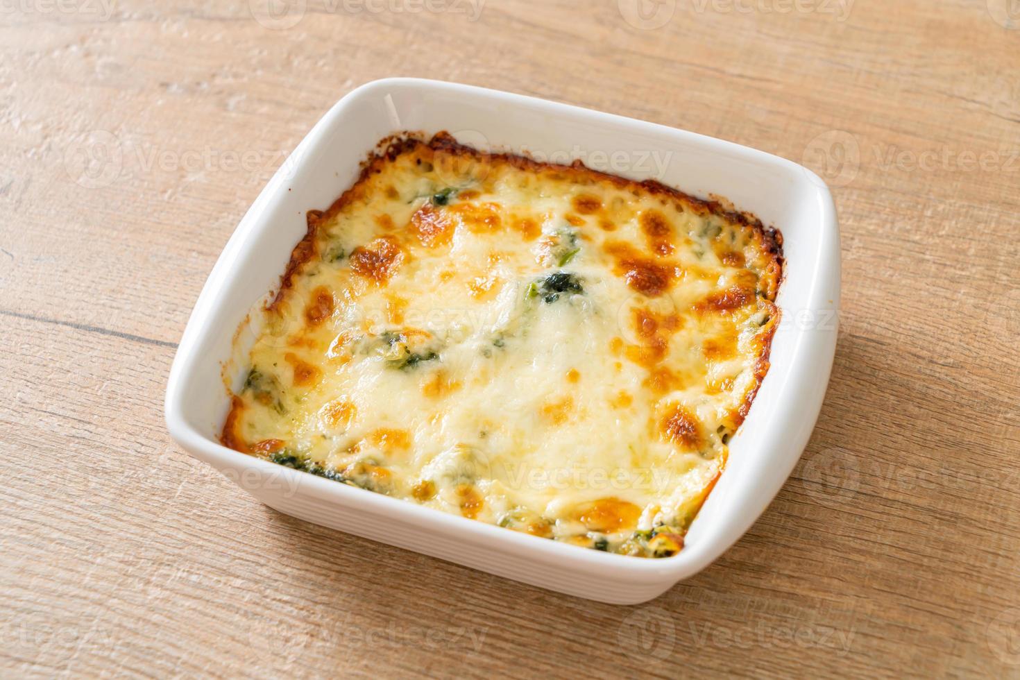 Lasaña de espinacas al horno con queso en placa blanca. foto