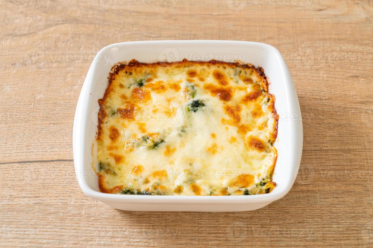 Lasaña de espinacas al horno con queso en placa blanca. foto