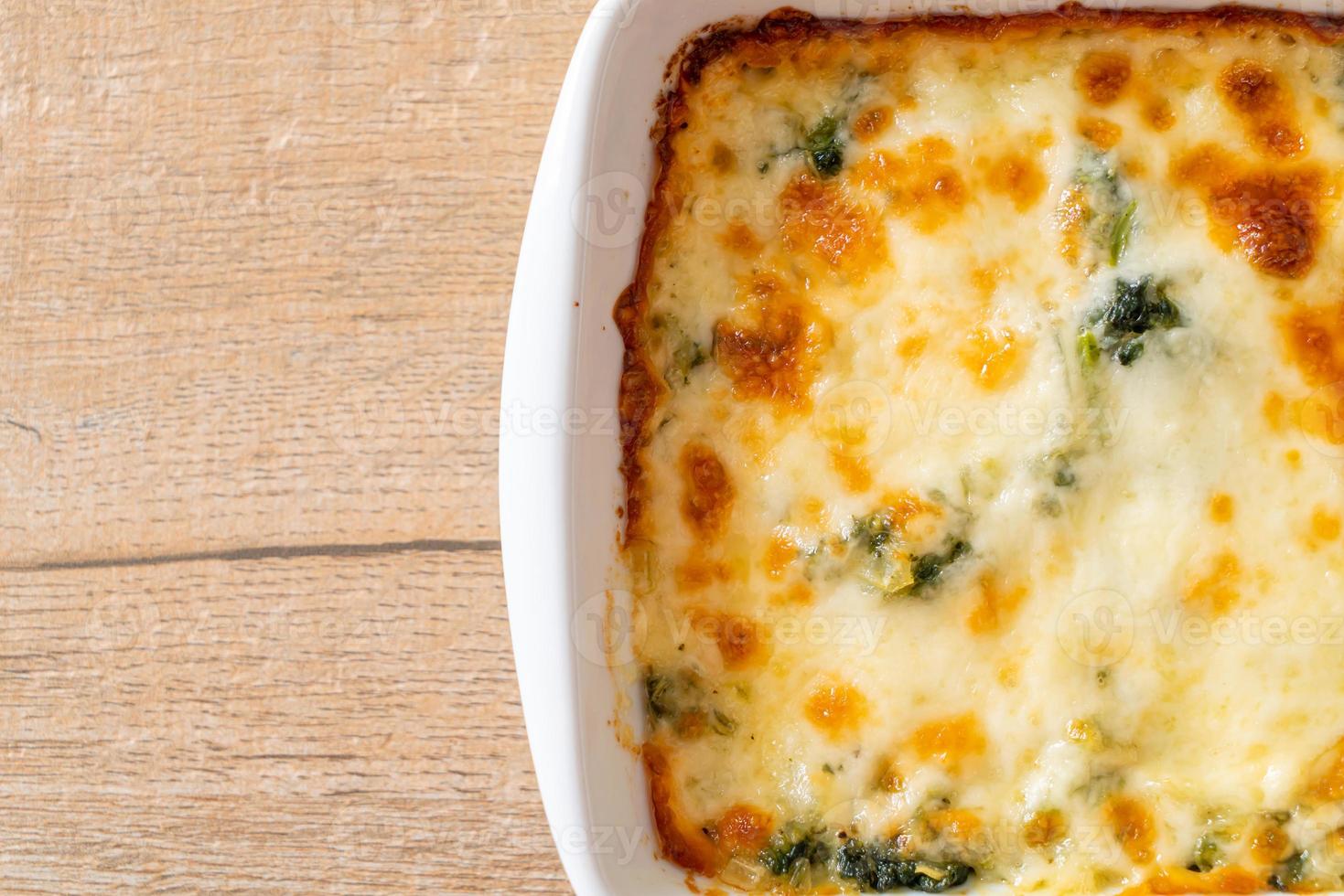 Lasaña de espinacas al horno con queso en placa blanca. foto