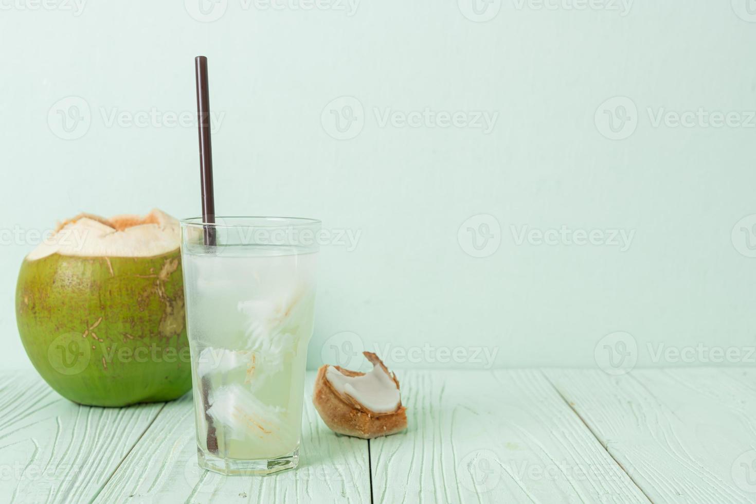 agua de coco o jugo de coco en vaso con cubitos de hielo foto