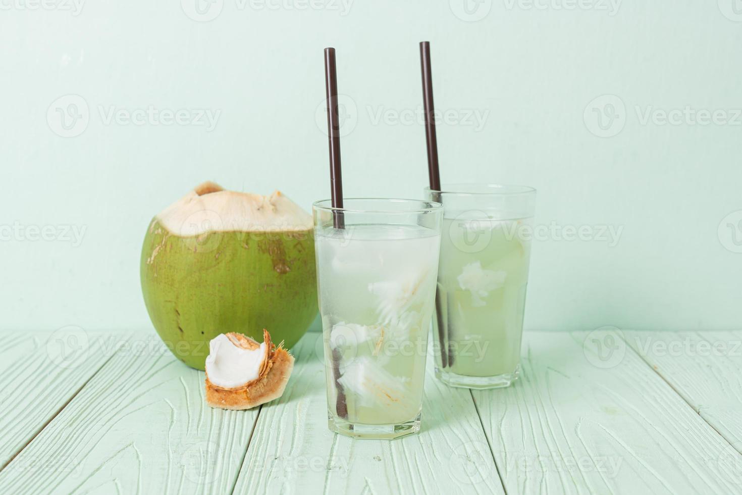 Coconut water or coconut juice in glass with ice cubes photo