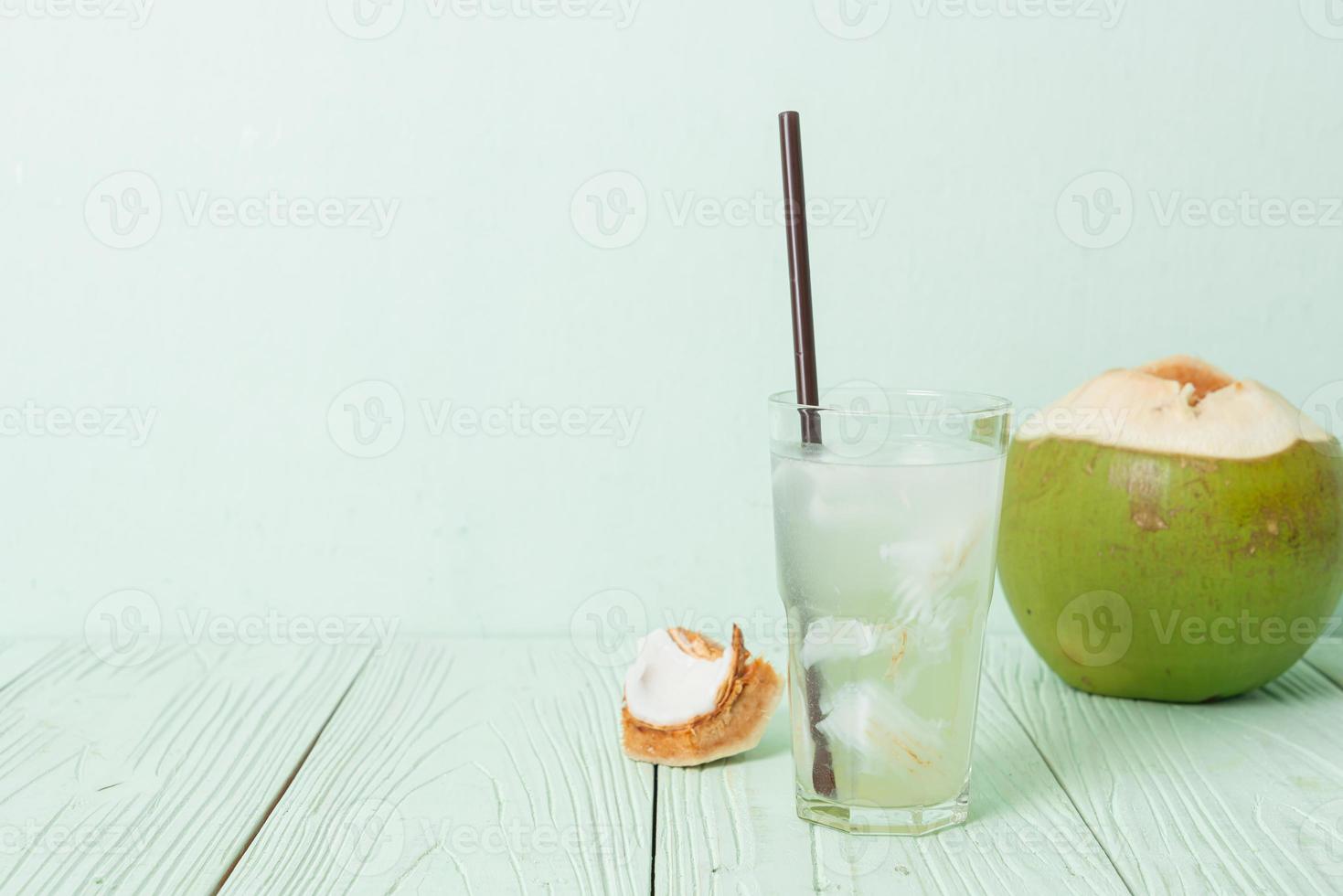 Coconut water or coconut juice in glass with ice cubes photo