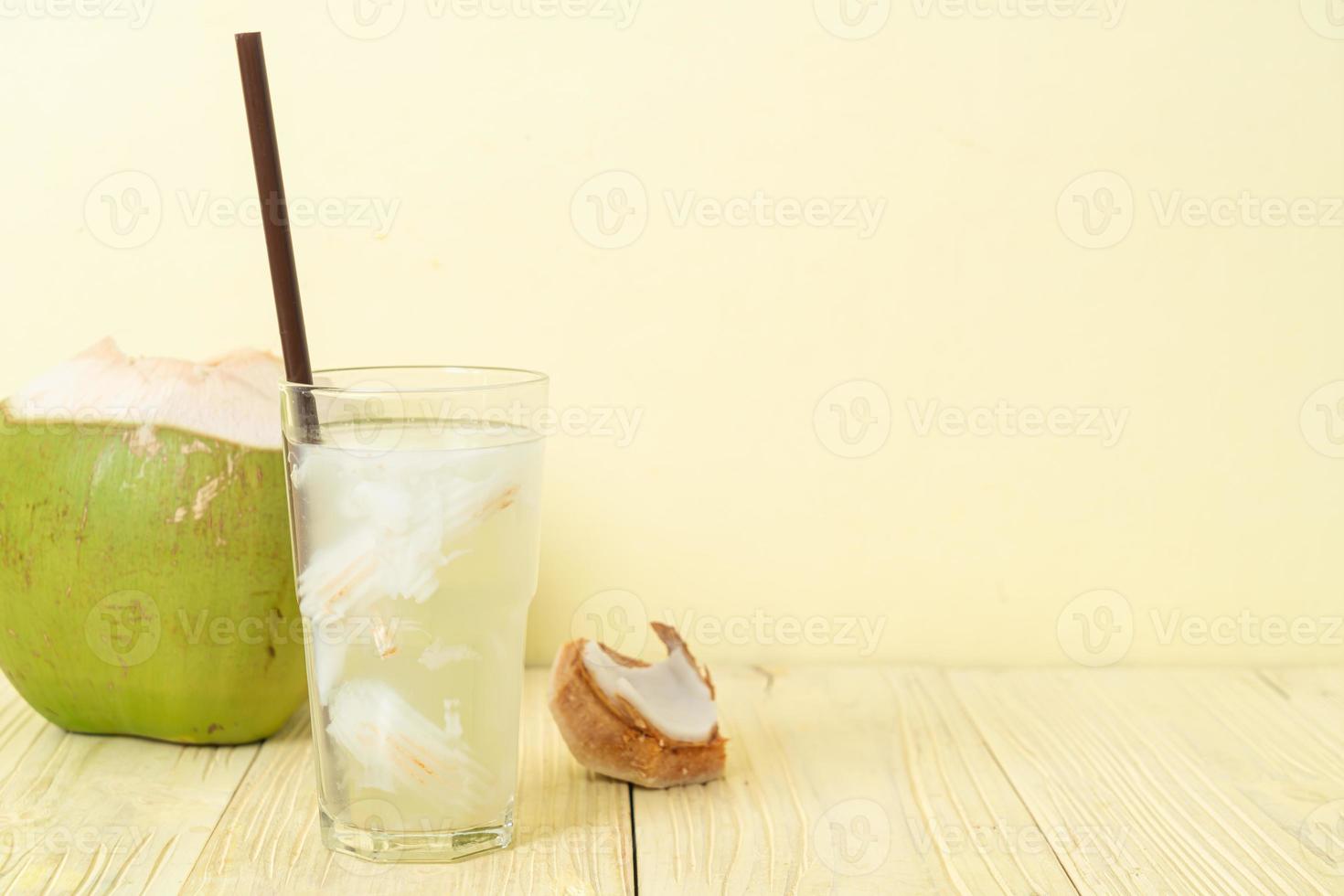 Coconut water or coconut juice in glass with ice cubes photo