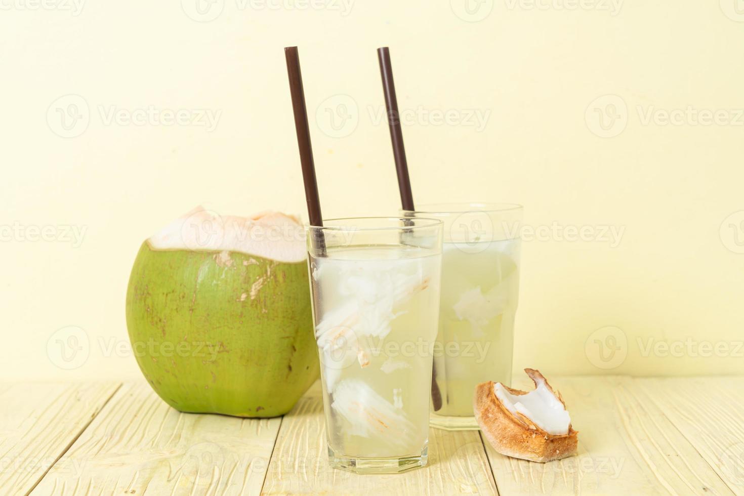 agua de coco o jugo de coco en vaso con cubitos de hielo foto