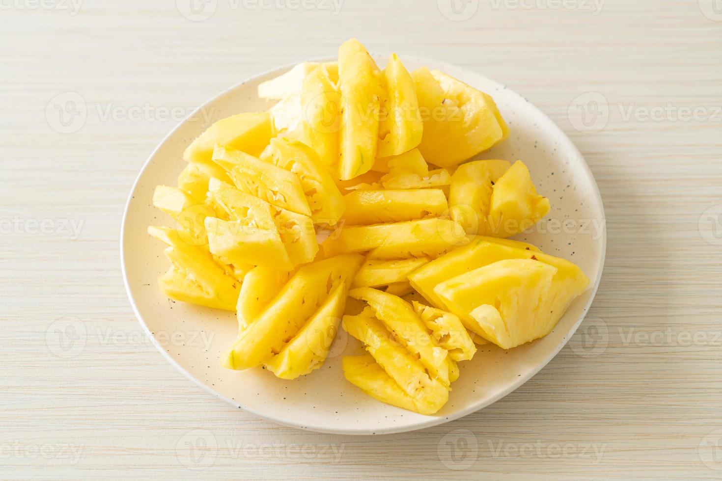 Fresh pineapple sliced on white plate photo