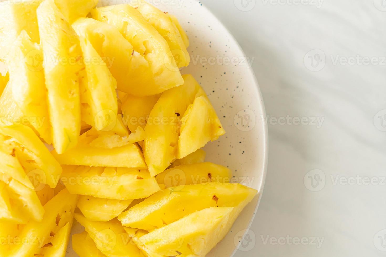 Fresh pineapple sliced on white plate photo