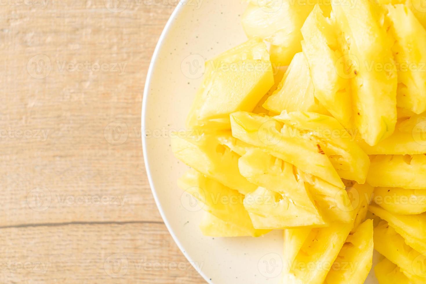 Fresh pineapple sliced on white plate photo