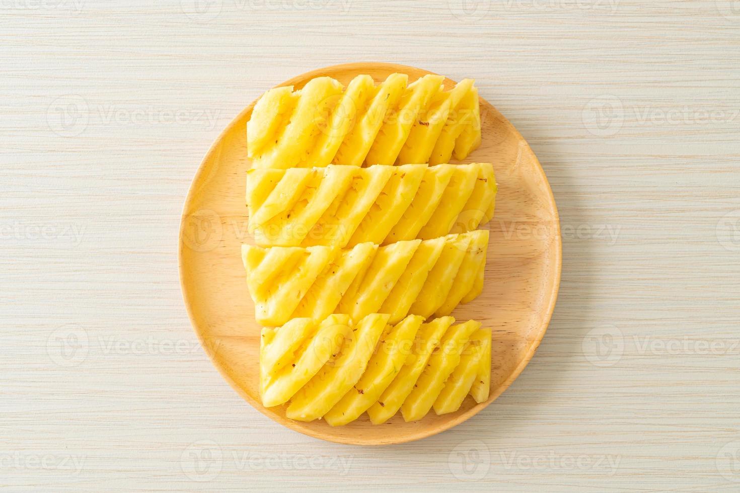 Fresh pineapple sliced on white plate photo