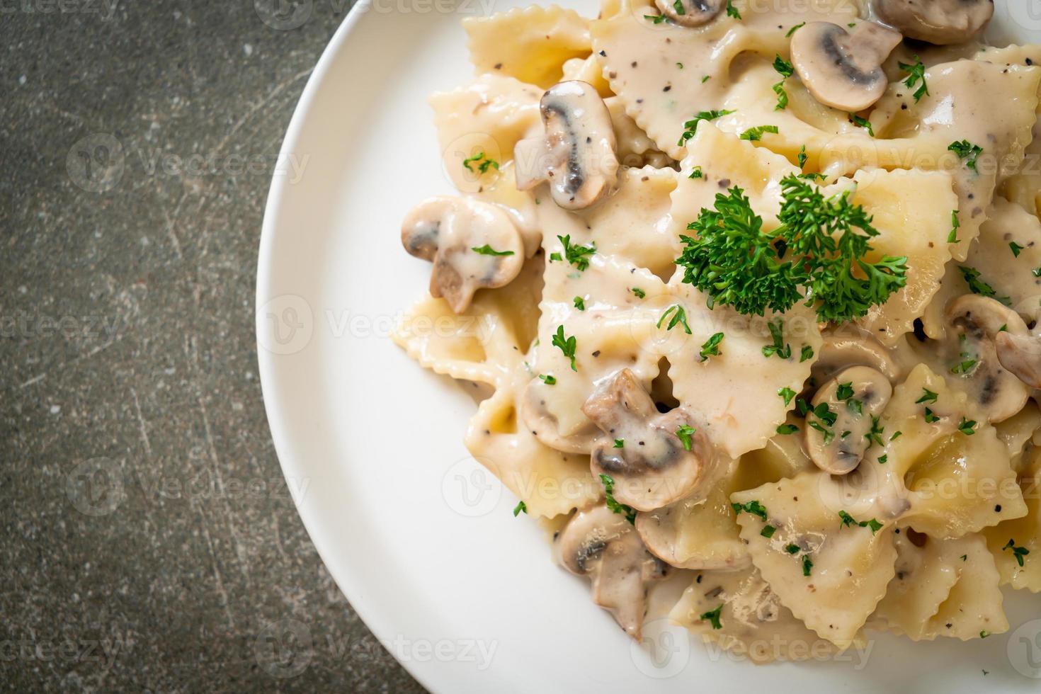 Pasta farfalle con salsa de crema blanca de champiñones - estilo de comida italiana foto