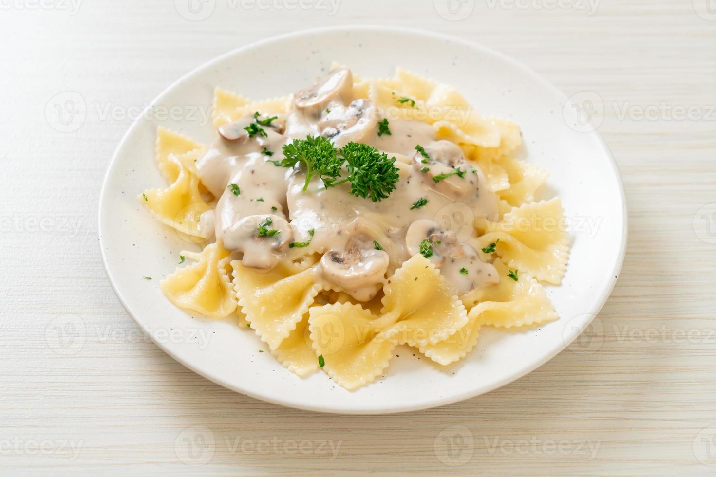 Pasta farfalle con salsa de crema blanca de champiñones - estilo de comida italiana foto