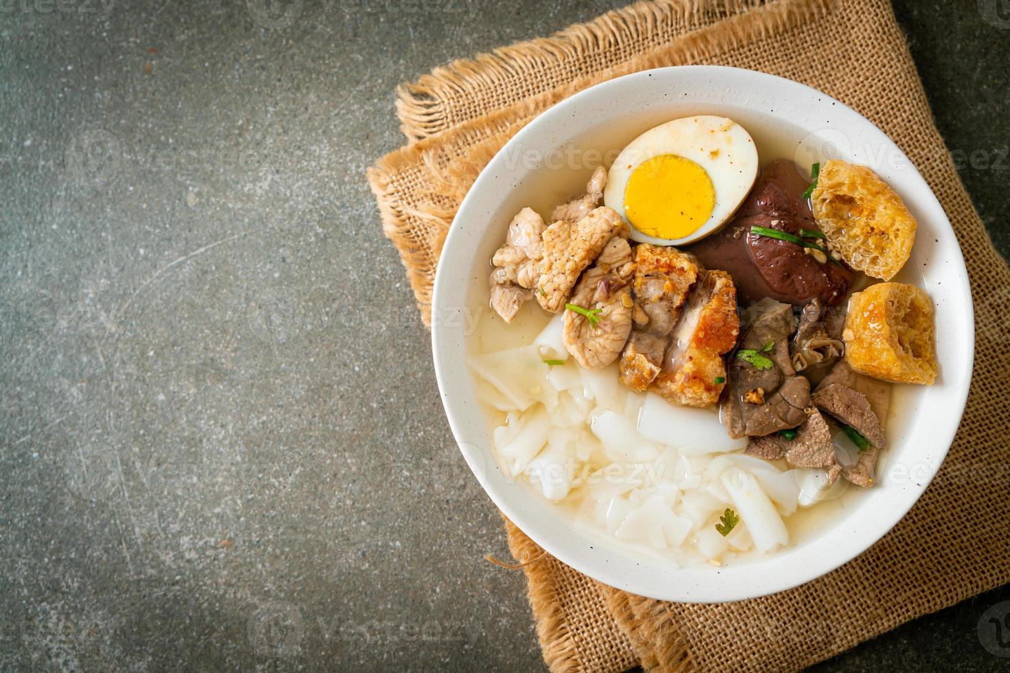 Paste of rice flour or boiled Chinese pasta square with pork in brown soup - Asian food style photo