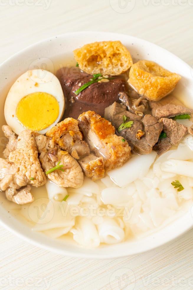 Paste of rice flour or boiled Chinese pasta square with pork in brown soup - Asian food style photo