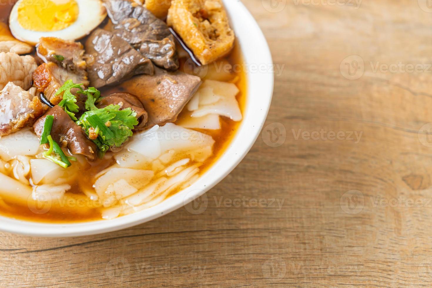 Paste of rice flour or boiled Chinese pasta square with pork in brown soup - Asian food style photo