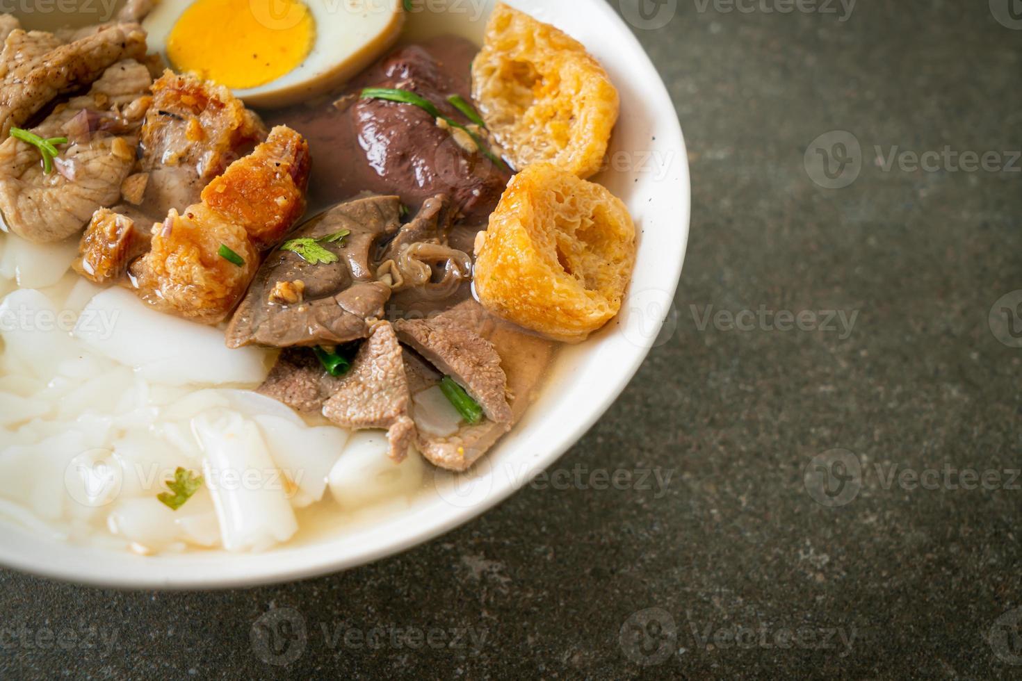 Paste of rice flour or boiled Chinese pasta square with pork in brown soup - Asian food style photo