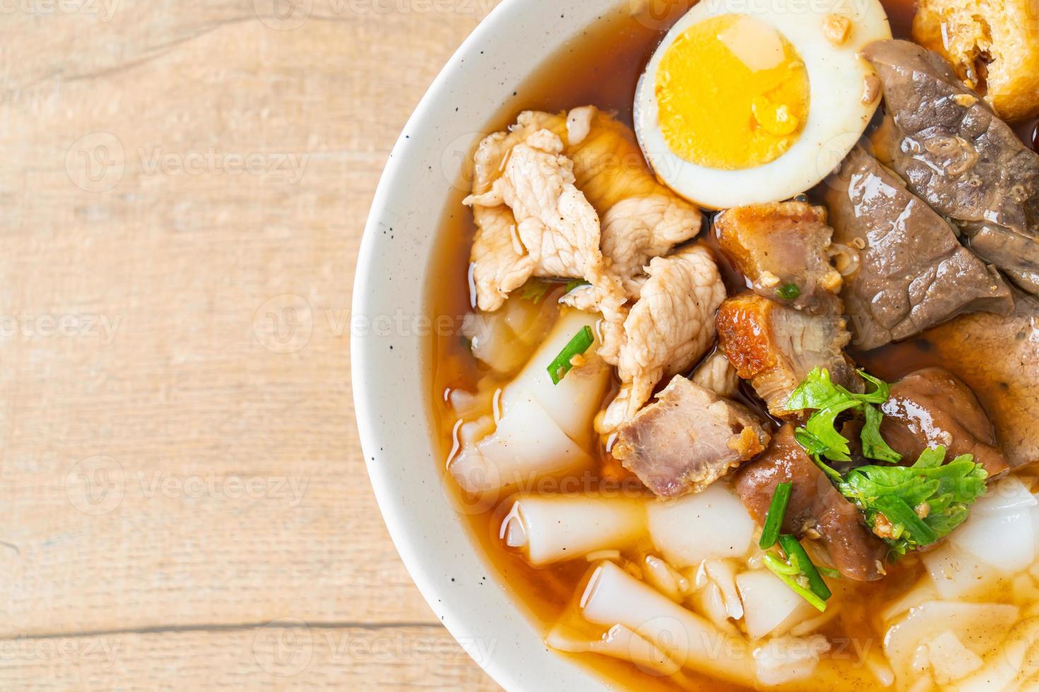 Paste of rice flour or boiled Chinese pasta square with pork in brown soup - Asian food style photo