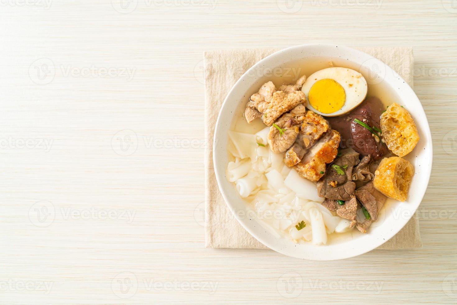 Pasta de harina de arroz o cuadrado de pasta china hervida con carne de cerdo en sopa marrón - estilo de comida asiática foto