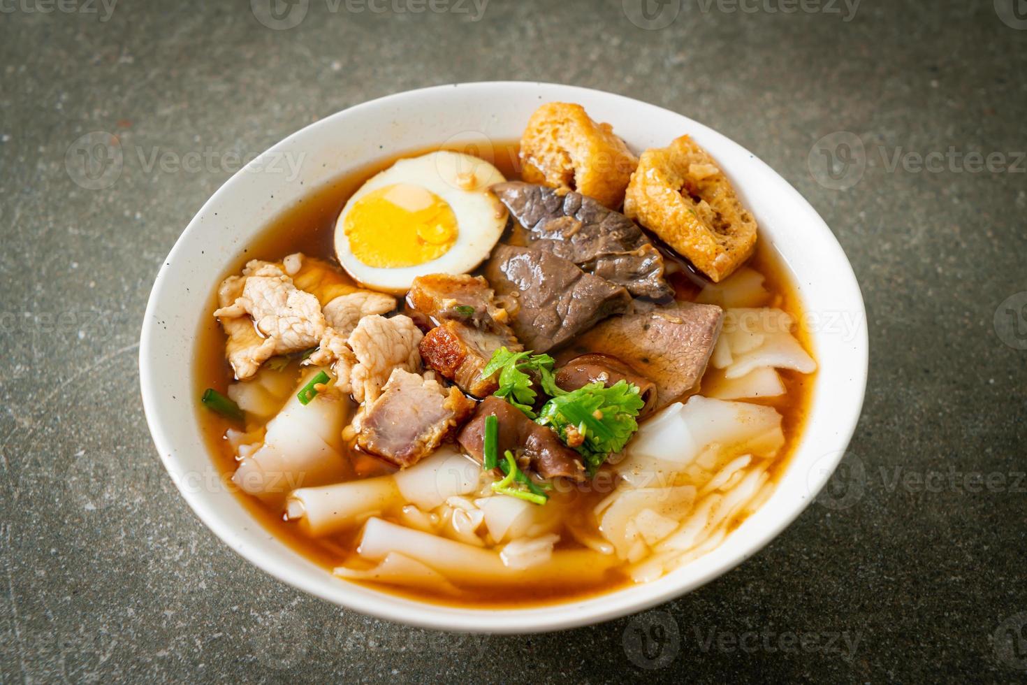 Paste of rice flour or boiled Chinese pasta square with pork in brown soup - Asian food style photo