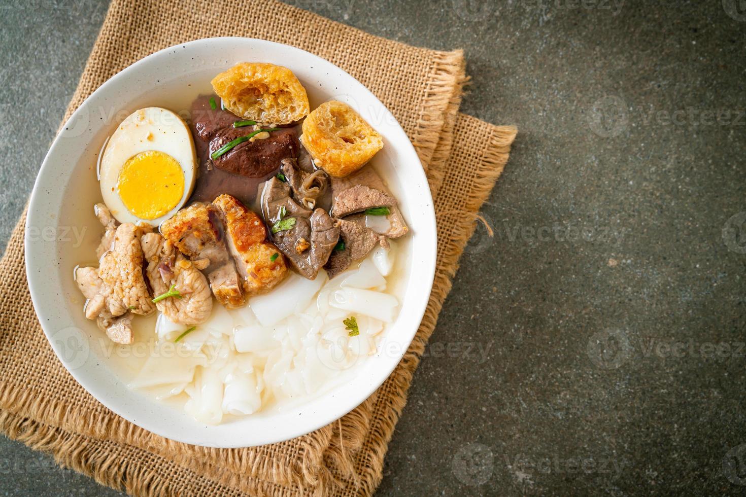 Paste of rice flour or boiled Chinese pasta square with pork in brown soup - Asian food style photo