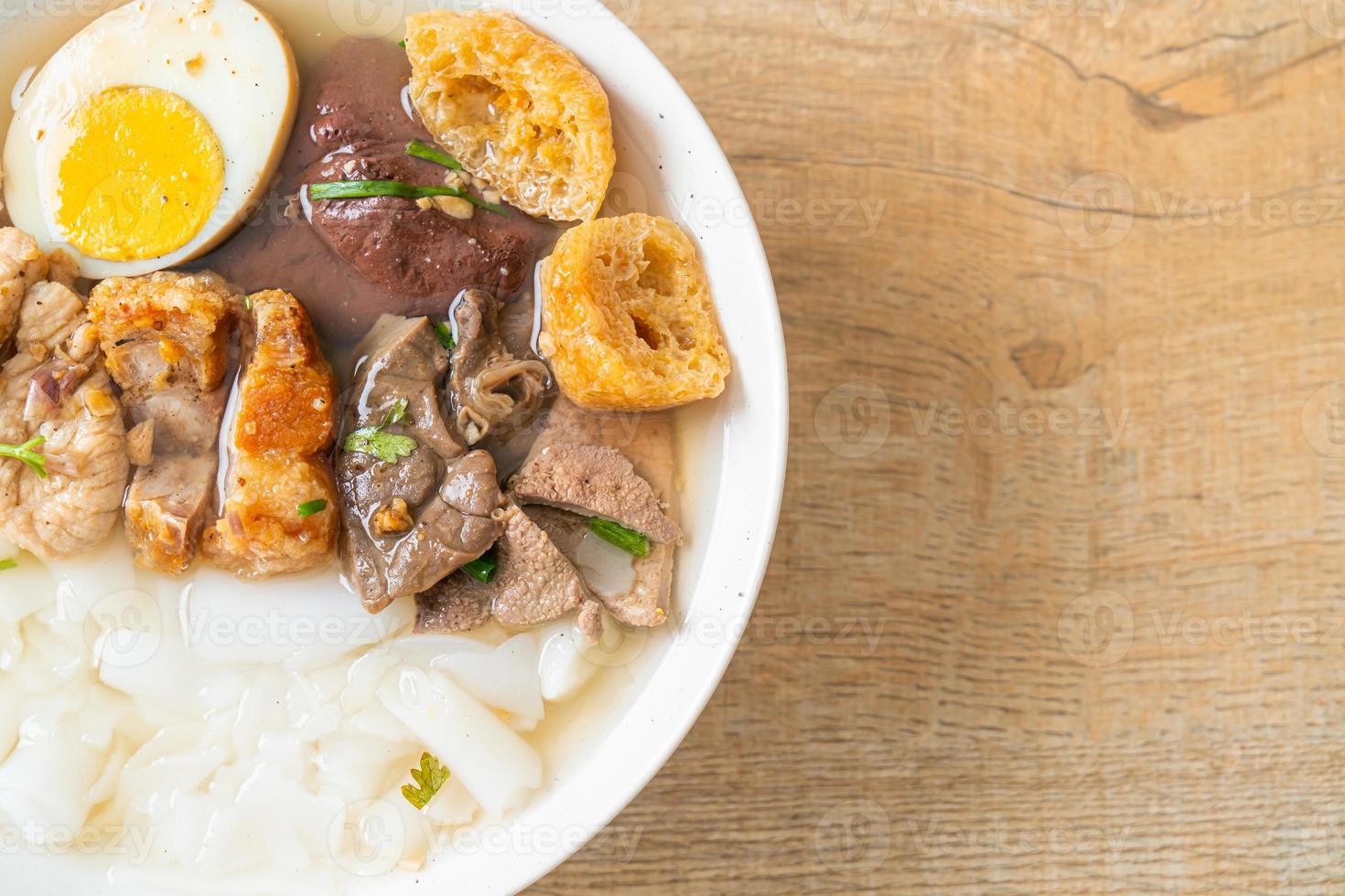Paste of rice flour or boiled Chinese pasta square with pork in brown soup - Asian food style photo