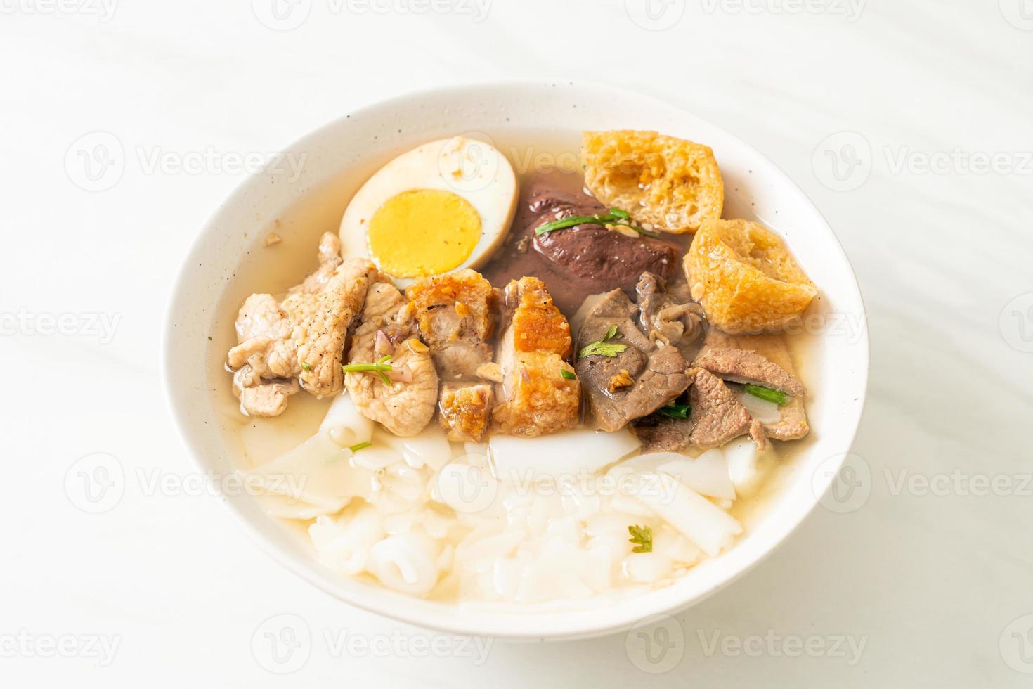 Paste of rice flour or boiled Chinese pasta square with pork in brown soup - Asian food style photo