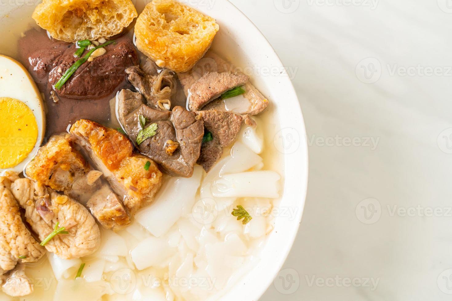 Paste of rice flour or boiled Chinese pasta square with pork in brown soup - Asian food style photo