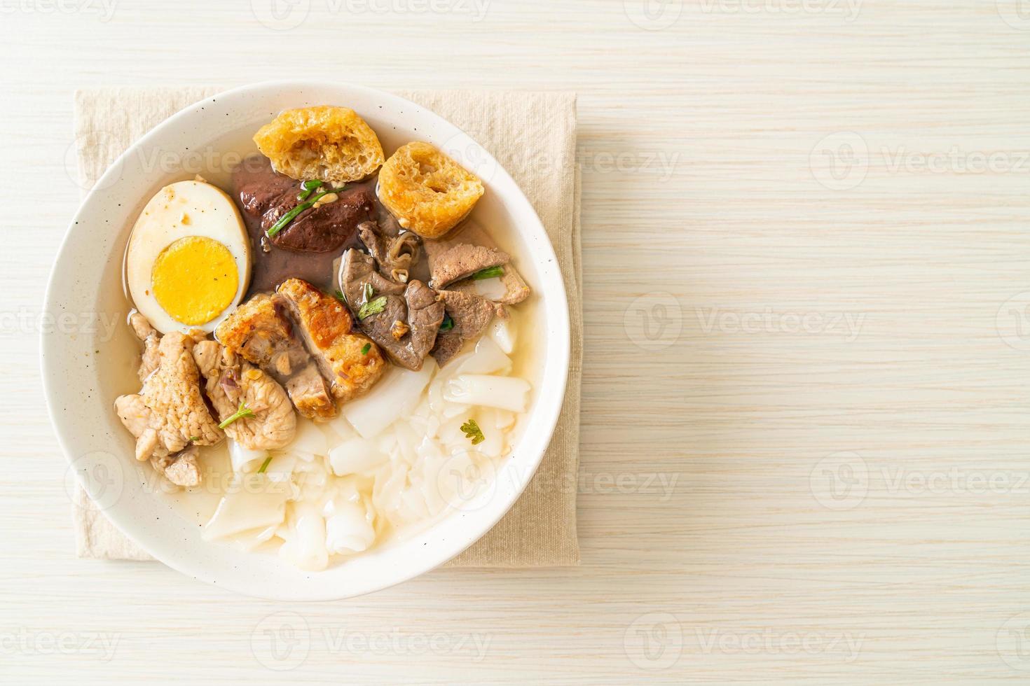 Pasta de harina de arroz o cuadrado de pasta china hervida con carne de cerdo en sopa marrón - estilo de comida asiática foto