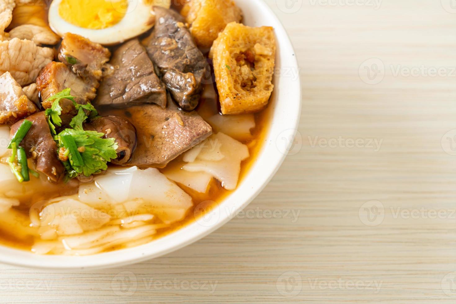 Paste of rice flour or boiled Chinese pasta square with pork in brown soup - Asian food style photo