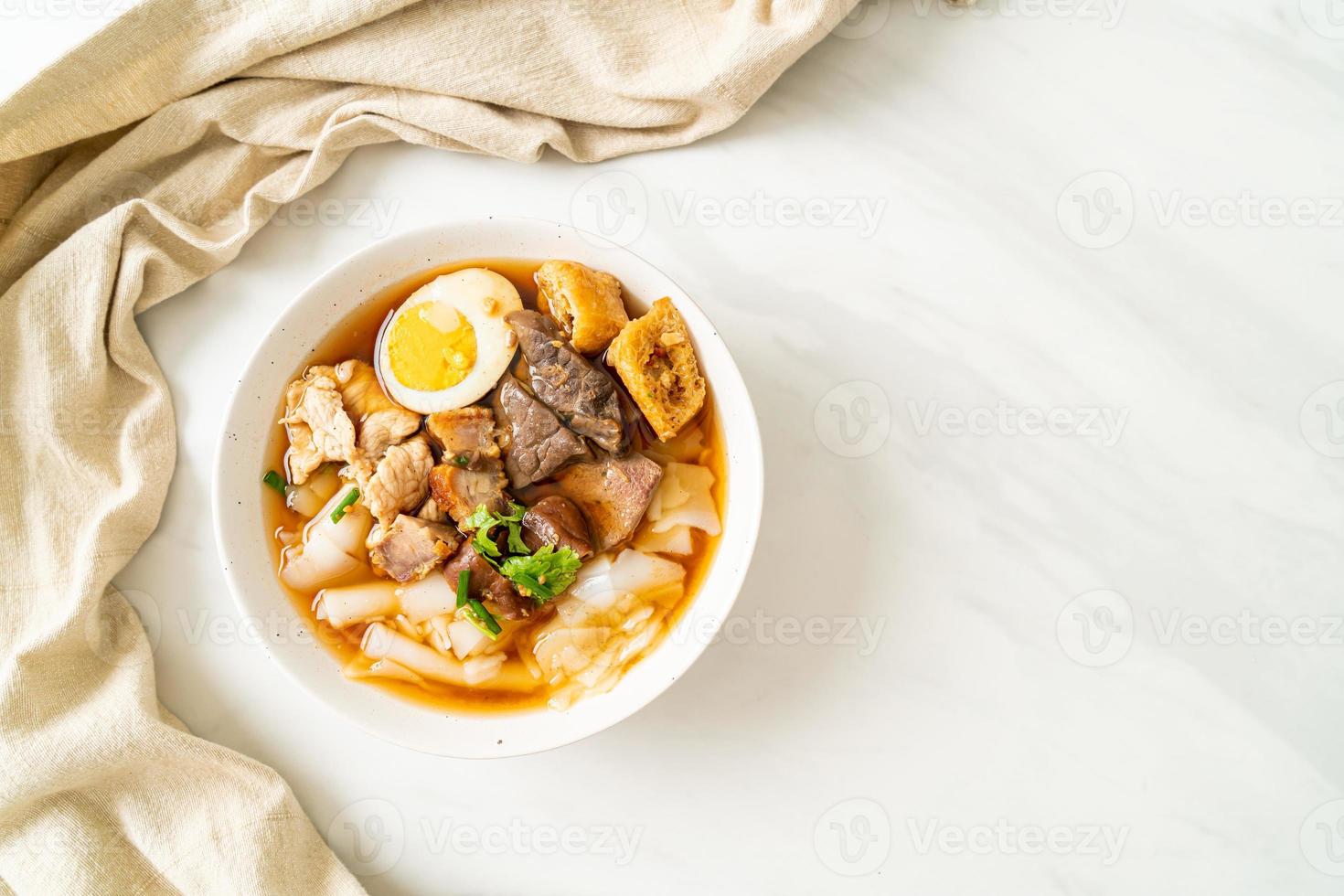 Paste of rice flour or boiled Chinese pasta square with pork in brown soup - Asian food style photo