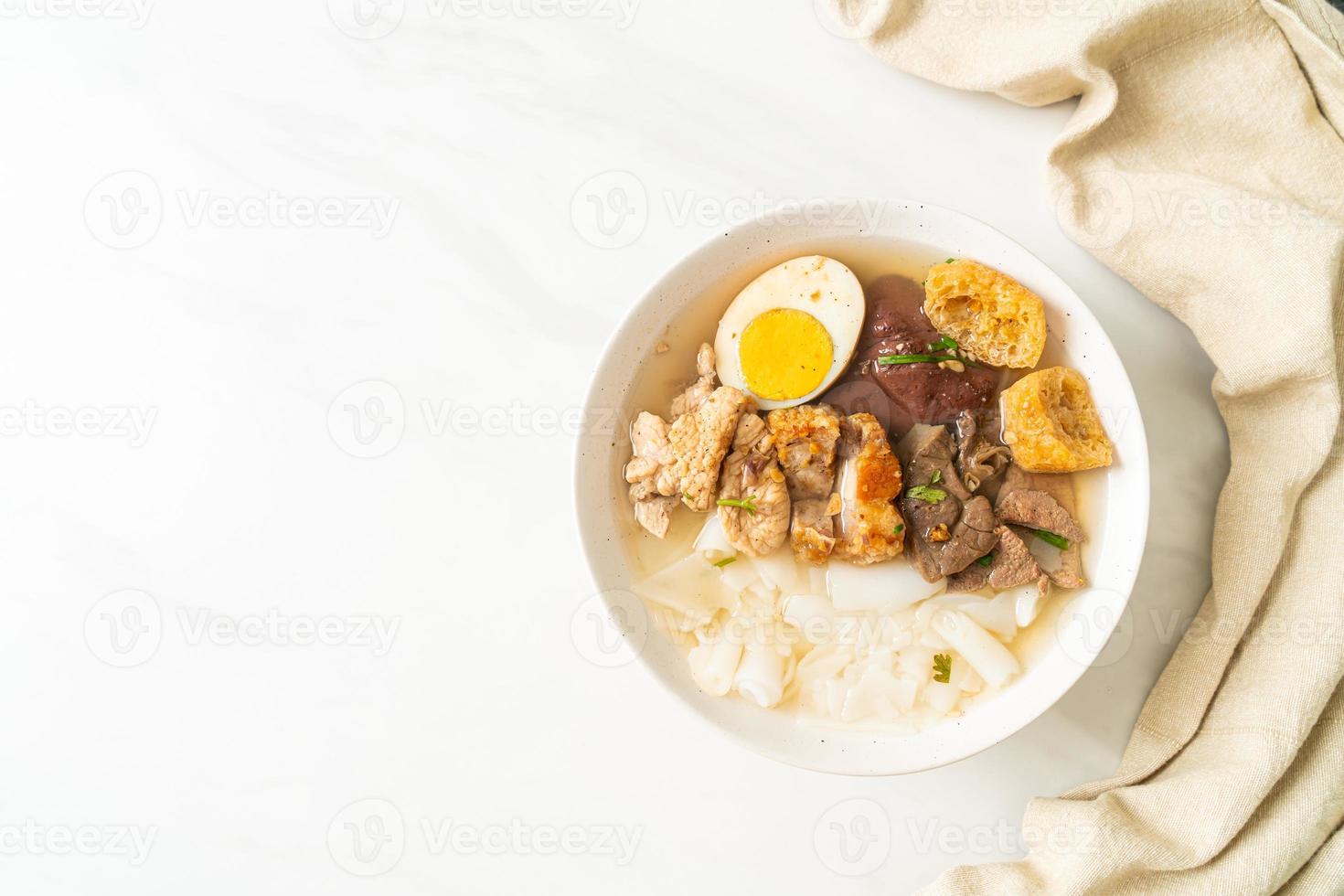 Pasta de harina de arroz o cuadrado de pasta china hervida con carne de cerdo en sopa marrón - estilo de comida asiática foto