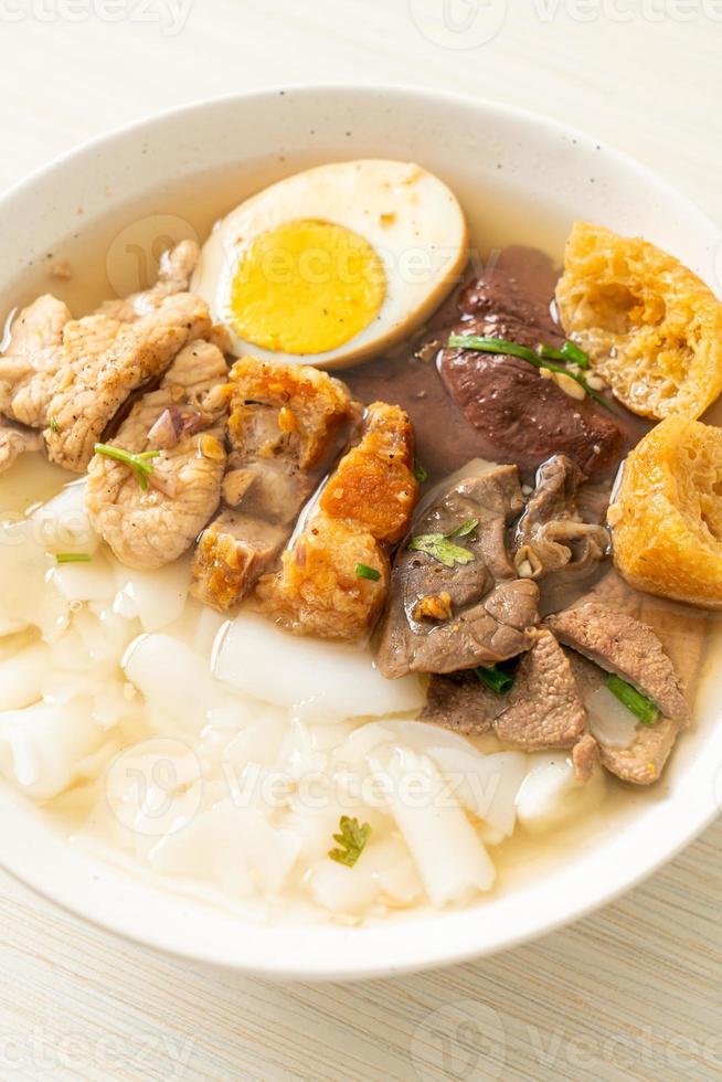 Paste of rice flour or boiled Chinese pasta square with pork in brown soup - Asian food style photo