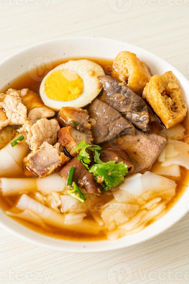 Paste of rice flour or boiled Chinese pasta square with pork in brown soup - Asian food style photo