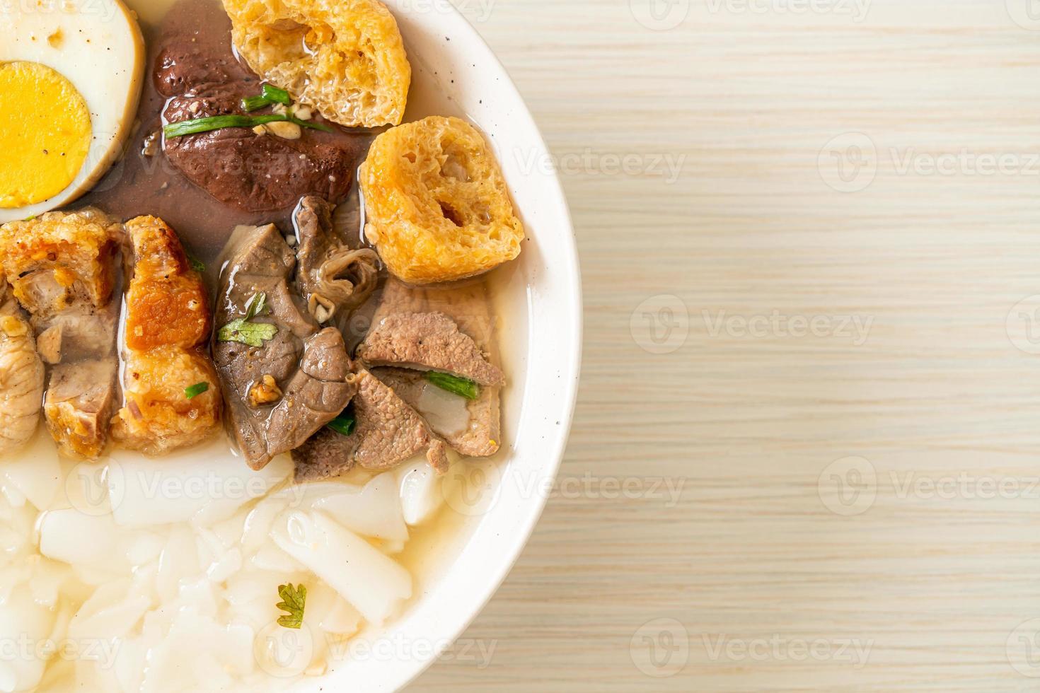 Paste of rice flour or boiled Chinese pasta square with pork in brown soup - Asian food style photo