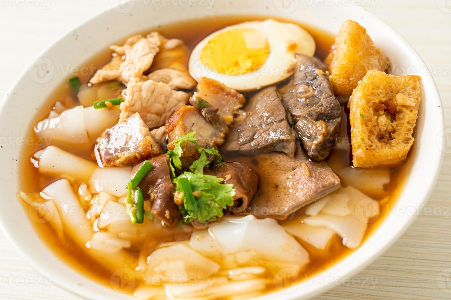 Paste of rice flour or boiled Chinese pasta square with pork in brown soup - Asian food style photo