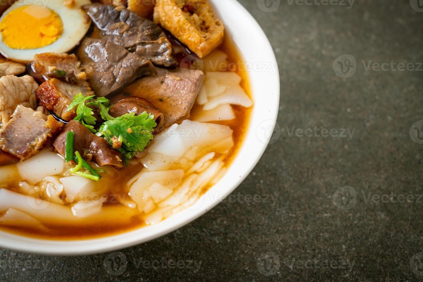 Paste of rice flour or boiled Chinese pasta square with pork in brown soup - Asian food style photo