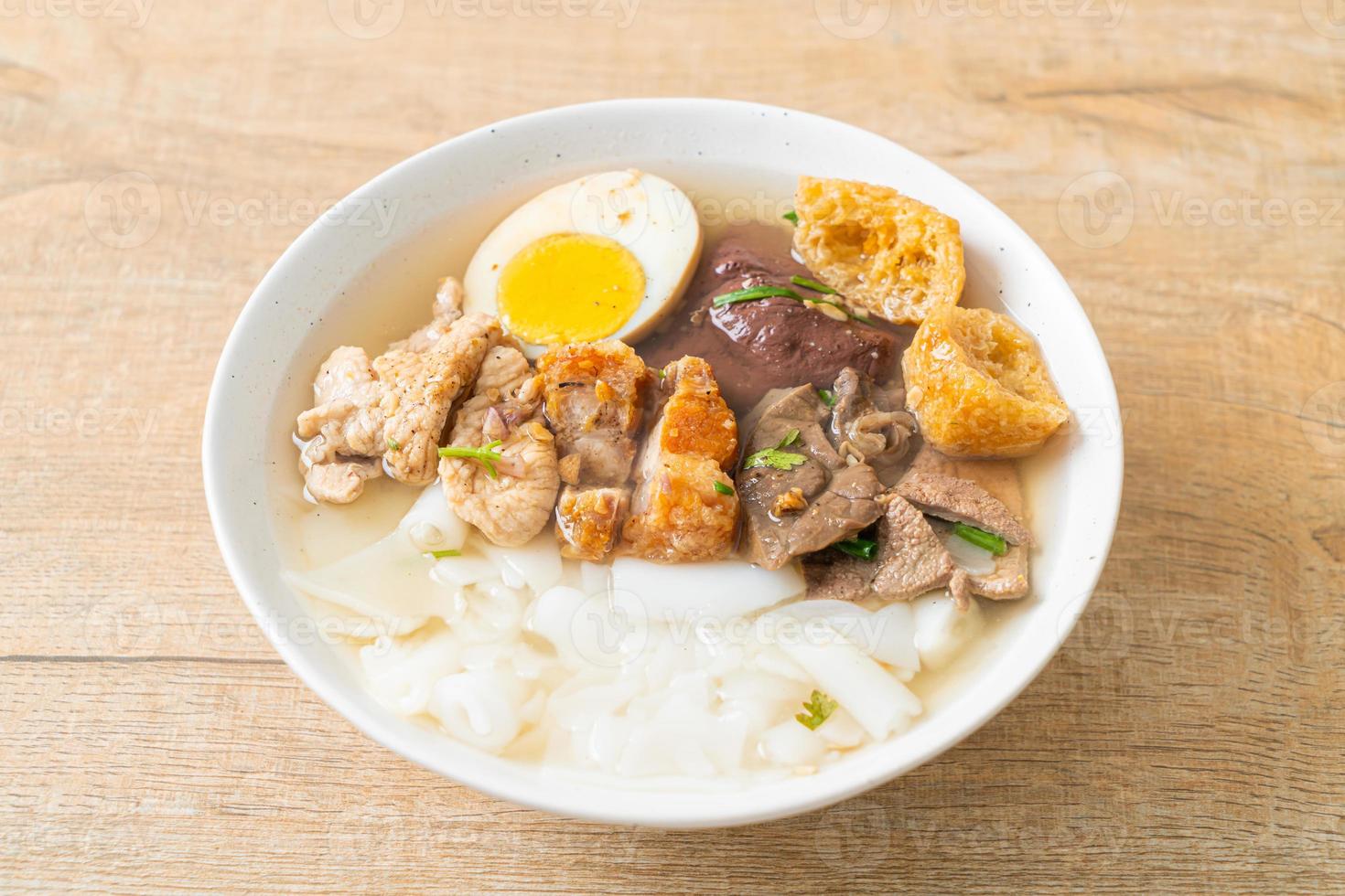 Paste of rice flour or boiled Chinese pasta square with pork in brown soup - Asian food style photo