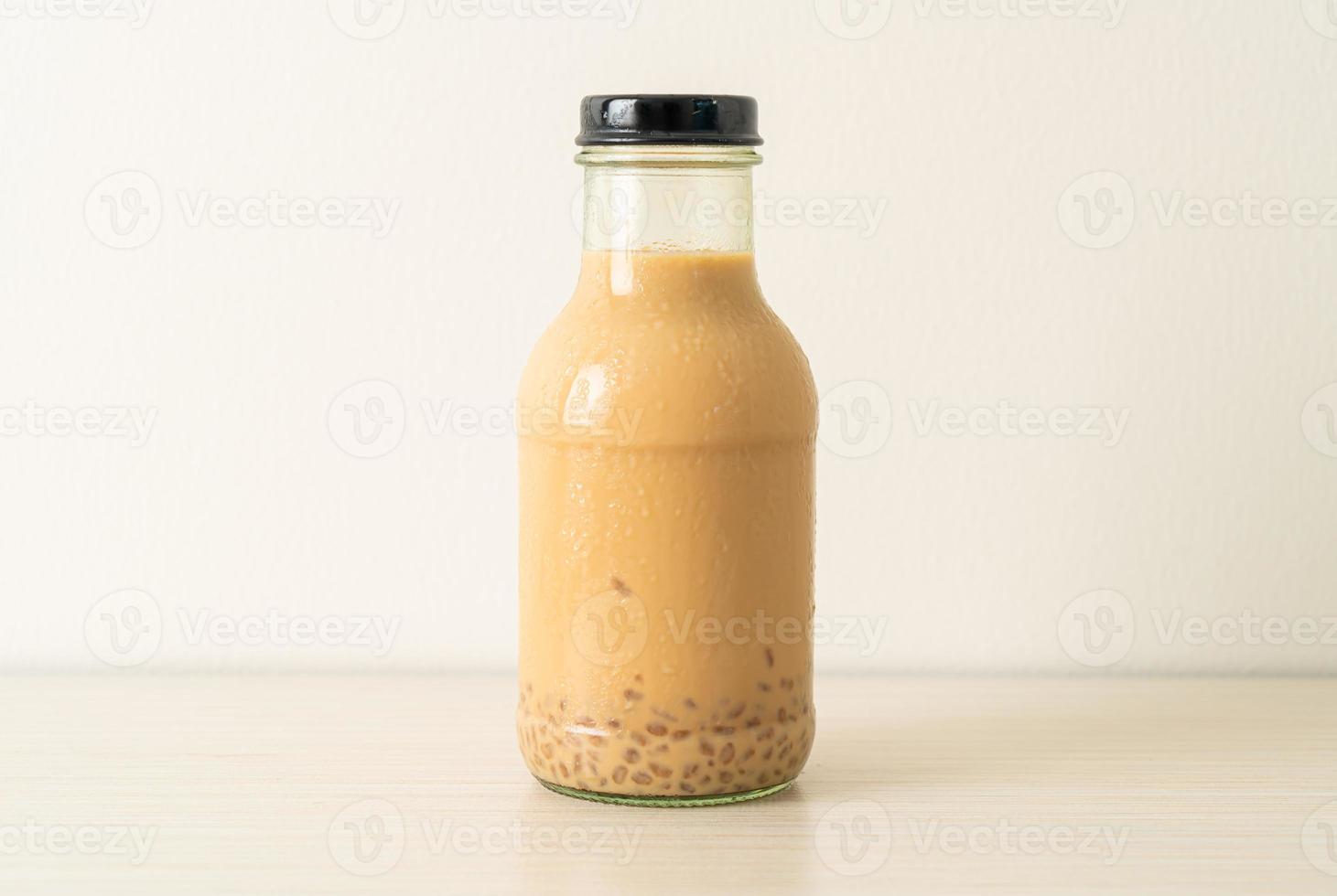 Milk tea with pudding jelly in glass bottle on the table photo