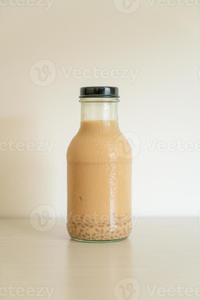 Milk tea with pudding jelly in glass bottle on the table photo