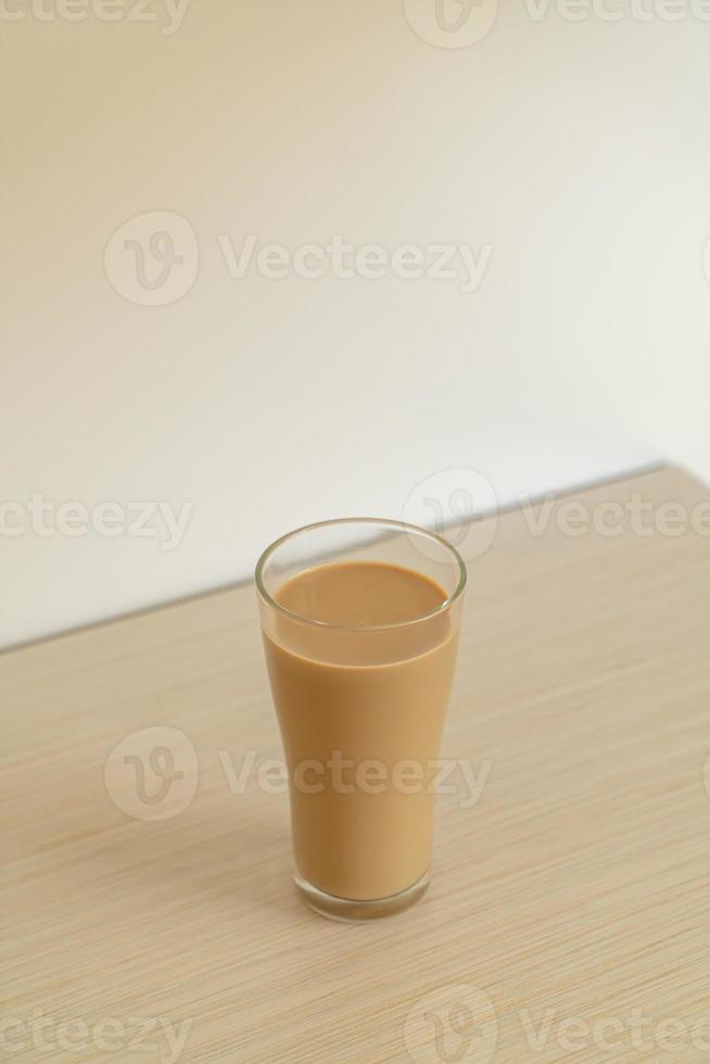 Vaso de café con leche con botellas de café listas para beber en la mesa foto