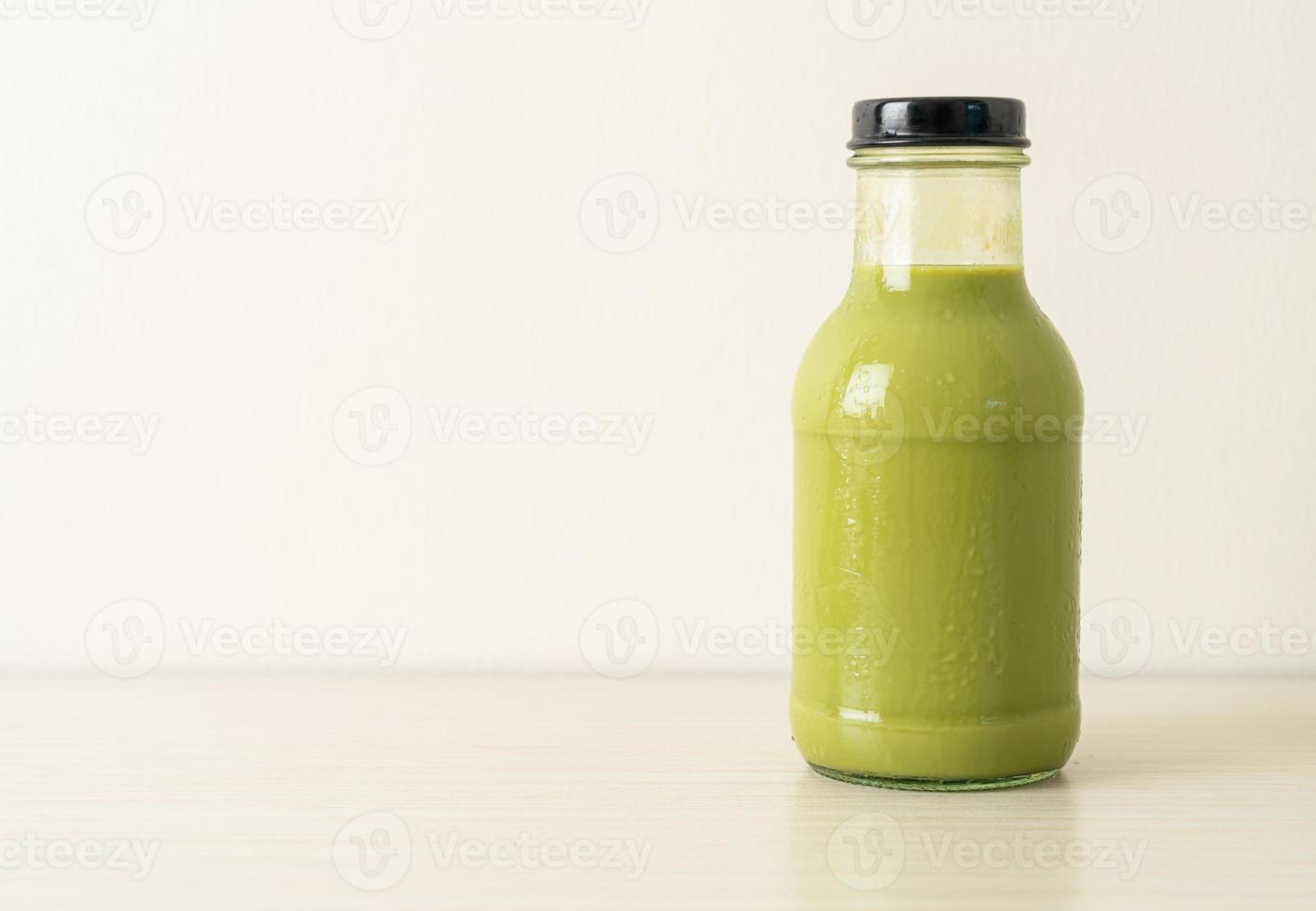 Latte de té verde matcha en botella de vidrio sobre la mesa foto